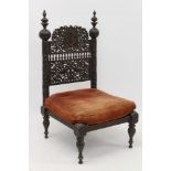 Late 19th / early 20th century Indian carved hardwood low chair with arched back intricately carved