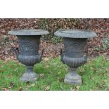 Pair of Classical revival cast iron campana garden urns with everted rim and twin handles on square