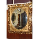 Large 19th century Florentine carved and pierced giltwood mirror oval bevelled plate in scrolling