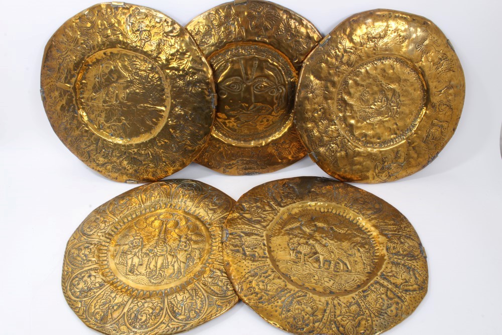 Five 19th Century Indian circular brass temple plates decorated in relief with Gods and figures,