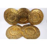 Five 19th Century Indian circular brass temple plates decorated in relief with Gods and figures,