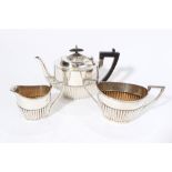 George V silver teapot of half fluted form with angular ebony handle and hinged domed and fluted