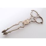 Pair late 18th century sugar tongs of conventional form, with scrolling decoration,