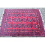 Tekke style rug with blood red ground and three rows of six octagonal medallions in geometric
