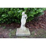 Weathered stone garden statue of a bather raised on stepped square plinth,