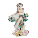 18th century Bow polychrome figure of a seated cupid with bow and quiver of arrows and floral