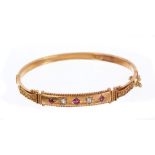 Edwardian ruby and diamond hinged bangle with three mixed cut rubies and two old cut diamonds in