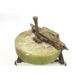 Antique mill stone with fragmentary wooden and metal mechanism,