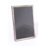 George V silver photograph frame of plain vertical rectangular form with oak easel back (Birmingham