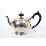 George V silver teapot of bullet form, in the Georgian style, with engraved foliate decoration,