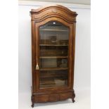 Continental walnut armoire with arched concave moulded cornice and enclosed by a bevelled glass