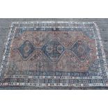 Large Eastern rug with three conjoined lozenge form medallions on brick red ground,