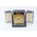 1930s French travelling alarm clock in gilt case raised on bun feet in original case,