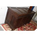 Large 17th century carved oak coffer with four panel hinged lid over geometric frieze and four