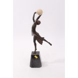 Bronzed Art Deco-style figure of a dancing semi-clad female figure holding a ball,