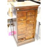 Early 20th century oak haberdashery cabinet with eighteen drawers and tambour shutter