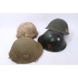 Collection of Military Helmets to include three British MK IV steel helmets, and an American steel