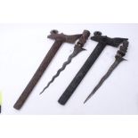 Two Malayan Kris Daggers in ornately carved wood scabbards with figural grips, one with a watered