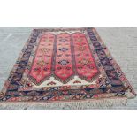 Persian carpet with geometric decoration on red and blue ground