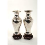Pair Chinese white metal vases on carved wooden stands
