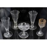 Three Georgian wrythen ale flutes, a gilt decorated liqueur glass and a lace makers' lamp (5)