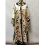 Chinese embroidered cream silk robe with figures, bats exotic birds, symbols in garden scene.
