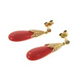 Pair of coral and diamond pendant earrings, each with pear shape coral drop and diamond set caps,