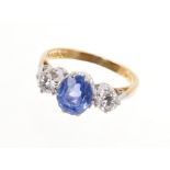 Sapphire and diamond three stone ring with an oval mixed cut blue sapphire weighing approximately 1.