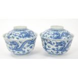 Pair 19th century Chinese blue and white bowls and covers with continuous five toed dragons chasing