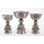 Three Eastern revolving white metal drinking cups