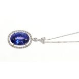 Tanzanite and diamond pendant with an oval mixed cut tanzanite estimated to weigh approximately 6.5