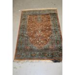 Kashan silk rug with bird and floral motifs on green and russet ground, 180cm x 122cm