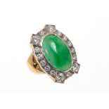 Jade and diamond cluster ring with an oval green jade cabochon surrounded by brilliant cut diamonds