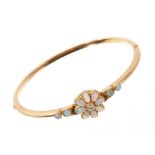 Edwardian opal and diamond hinged bangle, the flower head cluster with a central old cut diamond,