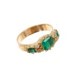 Victorian style emerald and diamond ring with three step cut emeralds and four old cut diamonds all