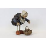 Unusual figure of a stooping lady, with pottery head and arms, and body constructed from a painted