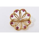 18ct gold brooch with a central brilliant cut diamond and eight mixed cut rubies