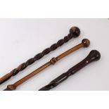 Exotic wood walking stick with carved knot and rondel handle together with two others with carved