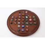 Victorian mahogany solitaire board and a collection of antique glass marbles