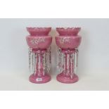 Pair of Victorian pink glass lustres with enamelled floral decoration and prismatic drops, 37cm in