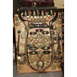 Superb mounted display board of antique horse brasses and tack, surmounted by bar of five bells, an