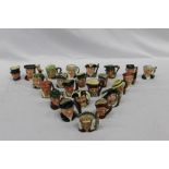 Twenty-three Royal Doulton character jugs including The Caroler D7007, Old Charley, Bacchus D6521