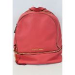 Michael Kors Pink leather back pack with engraved zipper pulls and circular logo lining.