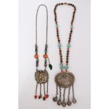 Old Chinese necklace with embossed white metal plaque with turquoise, coral and cat’s eye beads,