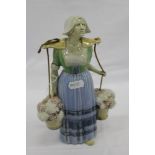 Unusual Royal Doulton Lambeth pottery figure of a woman carrying two baskets of flowers, with