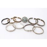 Group of Chinese and Eastern white metal and brass bangles, together with a large Thai/Eastern