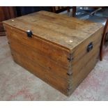 A 3' 2" old waxed pine and metal braced lift-top storage trunk with flanking iron drop handles and