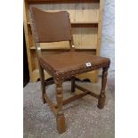 A pair of polished oak framed panel back dining chairs with studded brown leatherette upholstery and