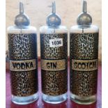 A retro set of three glass spirit decanters with leopard print decoration and pourer tops,