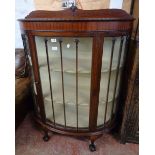 A 3' 5" early 20th Century mahogany bow front display cabinet with material lined shelves enclosed